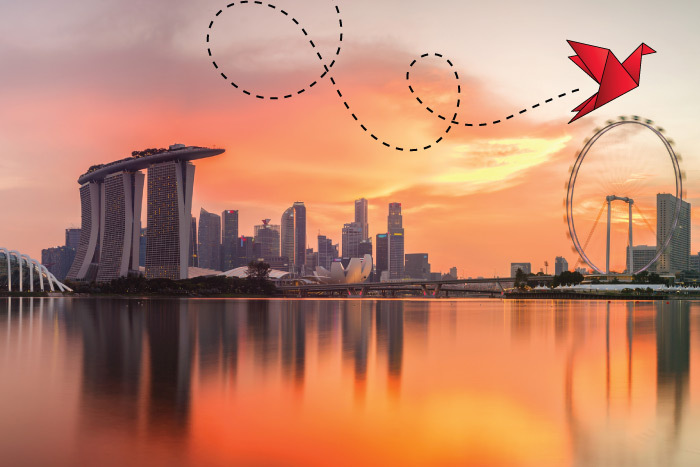 A city skyline with the Marina Bay Sands and a ferris wheel with a body of water